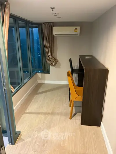 Modern study room with large windows and stylish furniture in high-rise apartment.