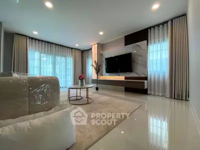 Luxurious modern living room with elegant decor and large windows.