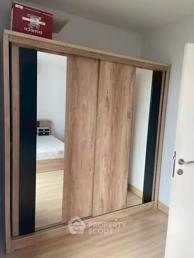 Spacious bedroom with modern wooden wardrobe and comfortable bed