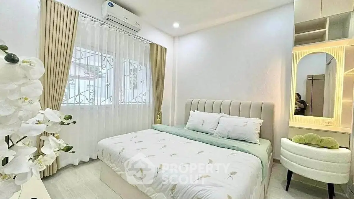 Cozy bedroom with elegant decor and natural light, featuring a comfortable bed and stylish vanity.