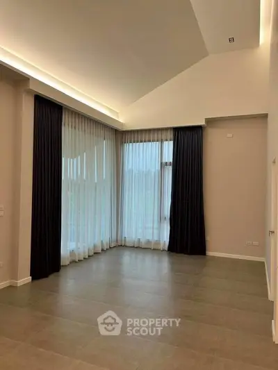 Spacious living room with high ceilings and large windows for natural light.