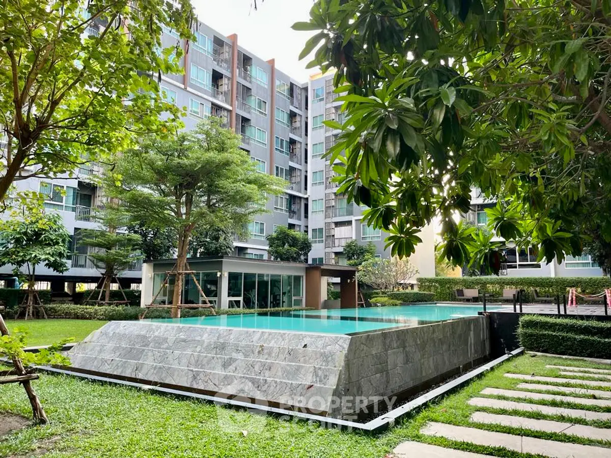 Modern apartment complex with lush garden and inviting swimming pool