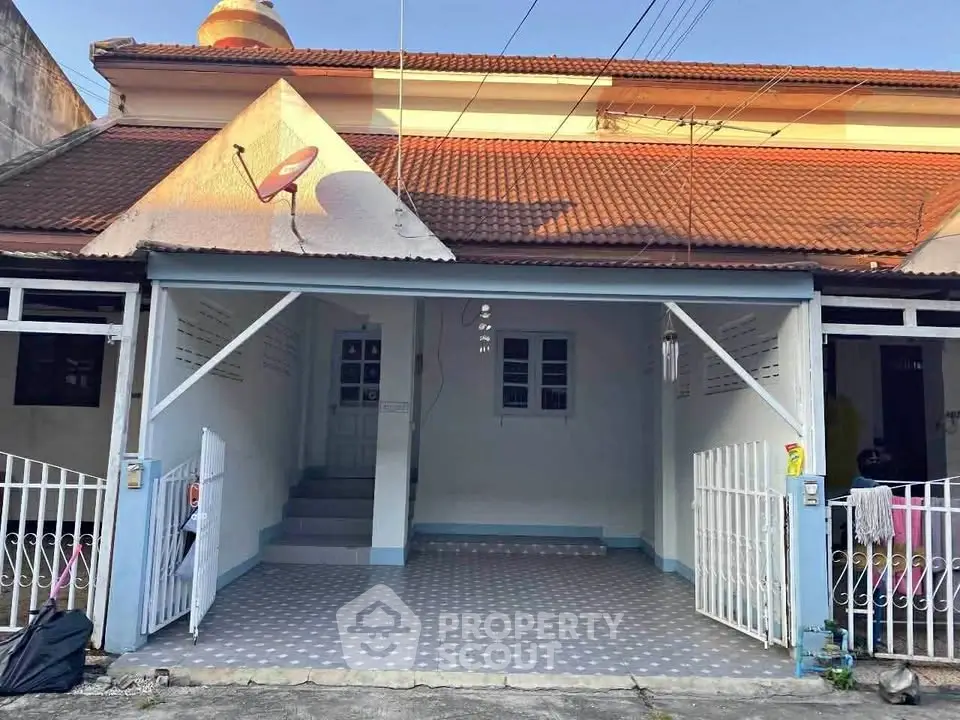 Charming single-story house with tiled roof and gated entrance, perfect for cozy living.