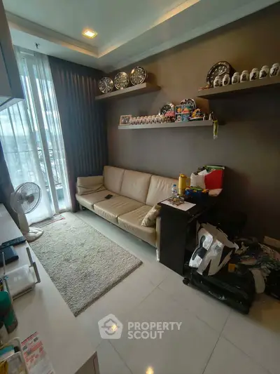Cozy living room with modern decor and natural light, featuring a comfortable sofa and stylish shelving.