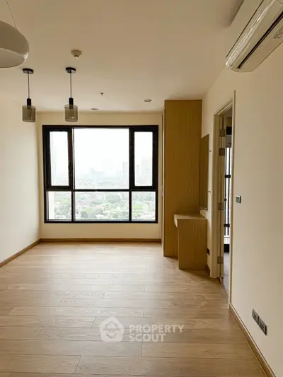 Bright and airy living room with large window and wooden flooring