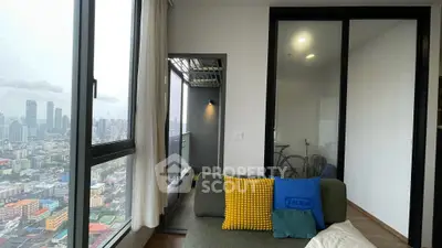 Modern living room with city view and balcony access in high-rise apartment.