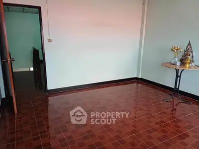 Spacious empty room with glossy tiled floor and open doorway, ideal for customization.