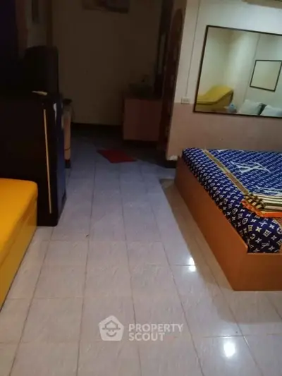 Cozy bedroom with tiled floor and modern furnishings, ideal for comfortable living.