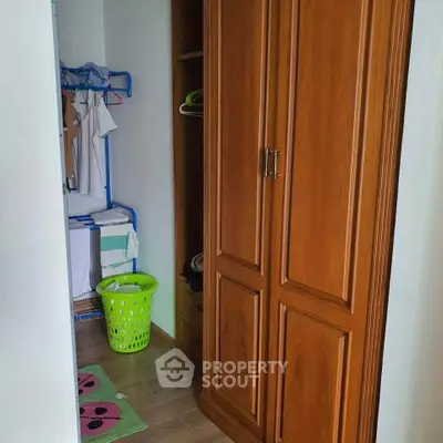 Cozy storage area with wooden wardrobe and laundry basket in modern home.