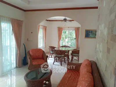 Charming living room with wicker furniture and natural light, perfect for relaxation.