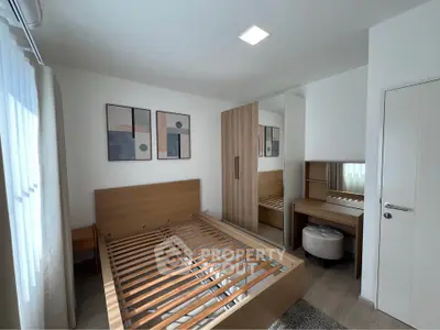 Modern bedroom with wooden bed frame, mirrored wardrobe, and stylish decor.