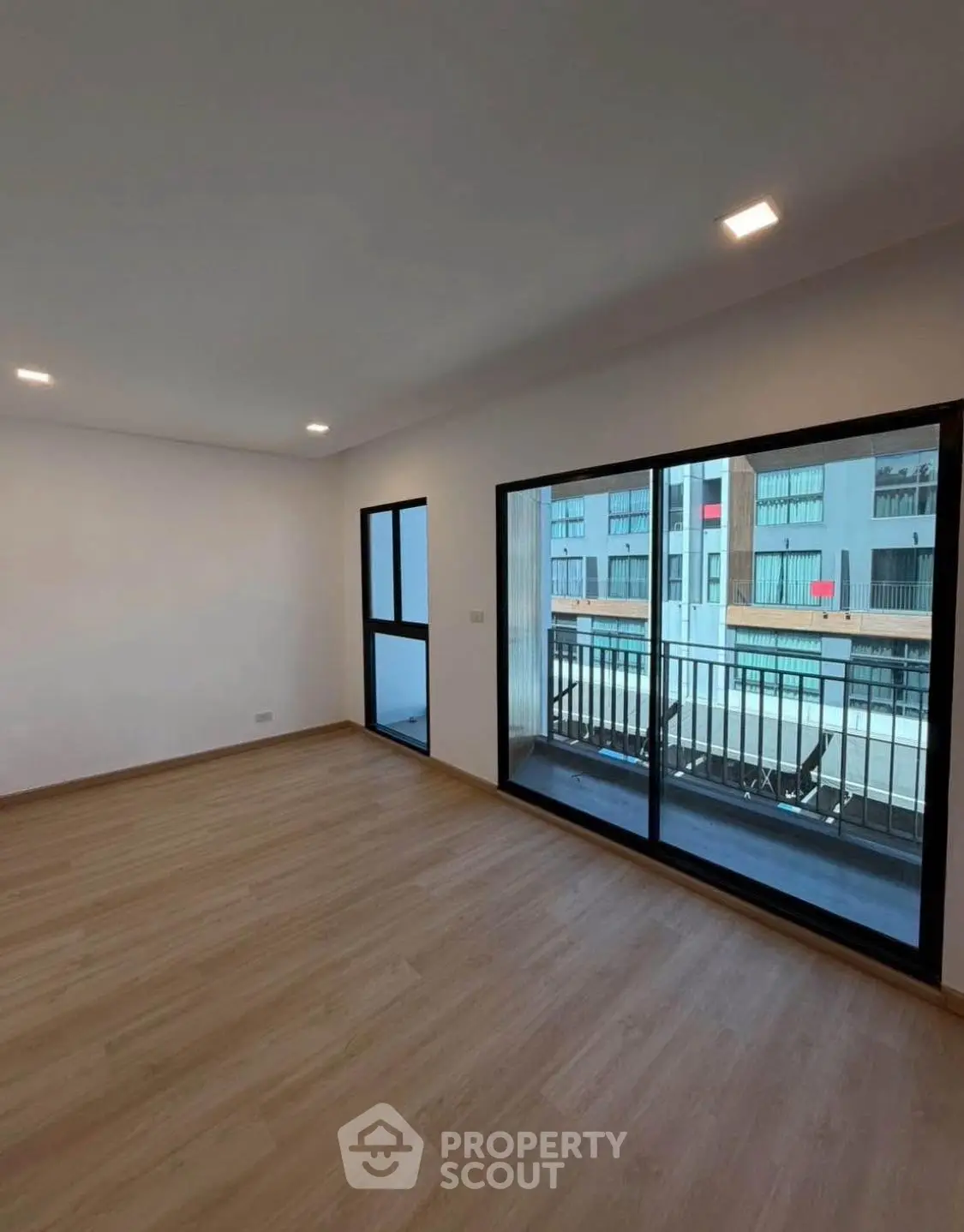 Spacious modern living room with large windows and balcony view