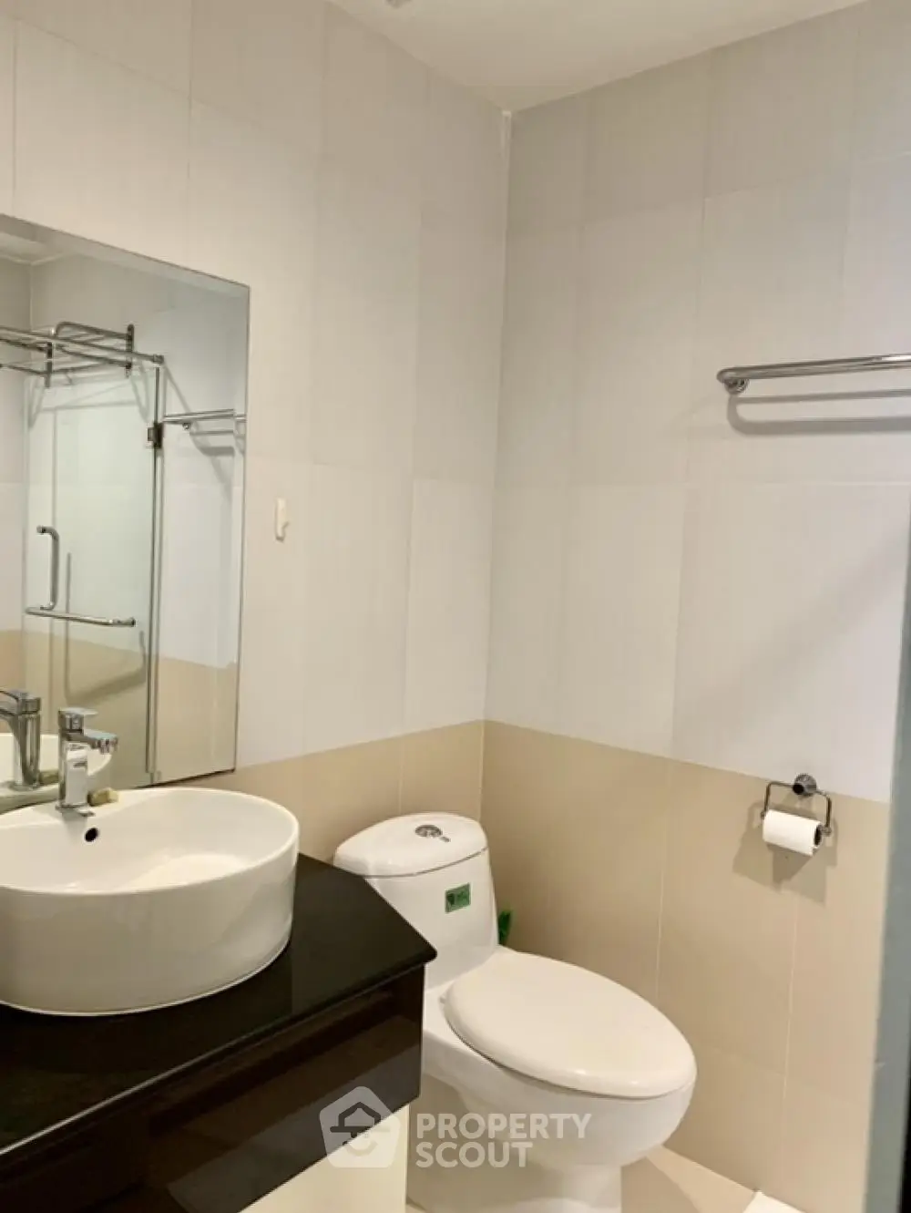 Modern bathroom with sleek fixtures and neutral tones, featuring a stylish sink and toilet.