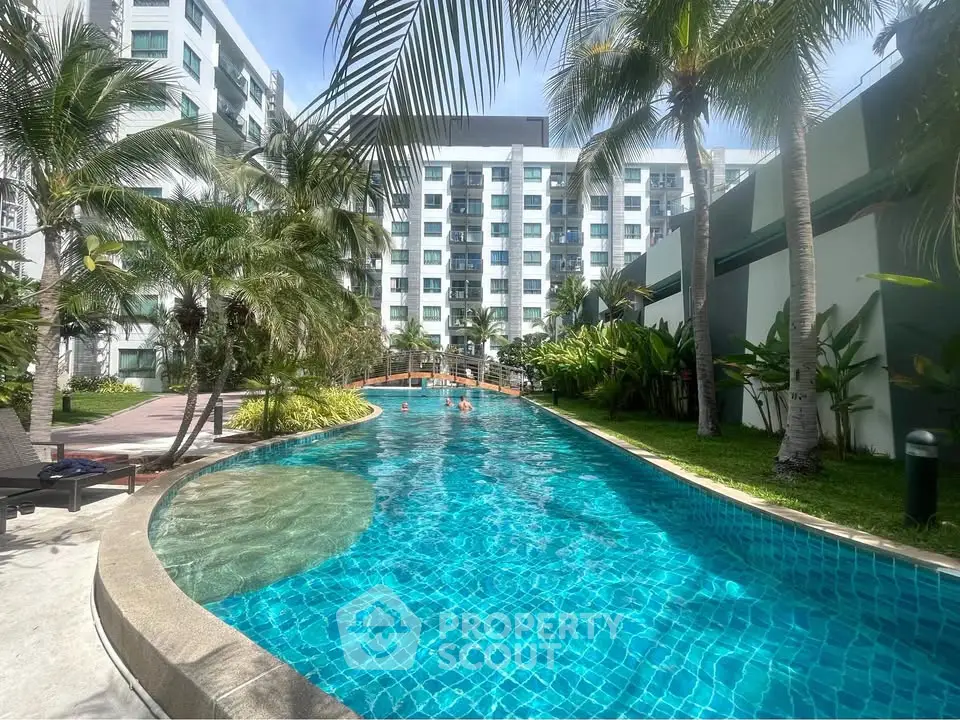 Luxurious condominium with stunning pool and lush palm trees, perfect for resort-style living.