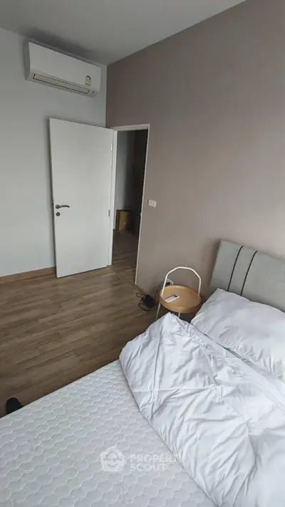 Cozy bedroom with modern air conditioning and wooden flooring