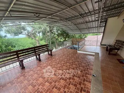 Spacious covered balcony with scenic views and tiled flooring, perfect for relaxation.