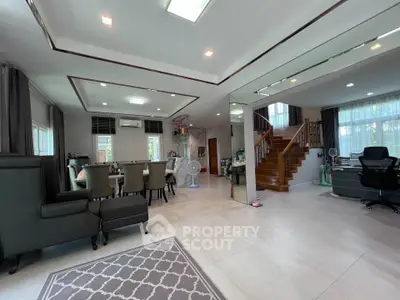 Spacious modern living room with elegant dining area and staircase, featuring sleek furniture and ample natural light.