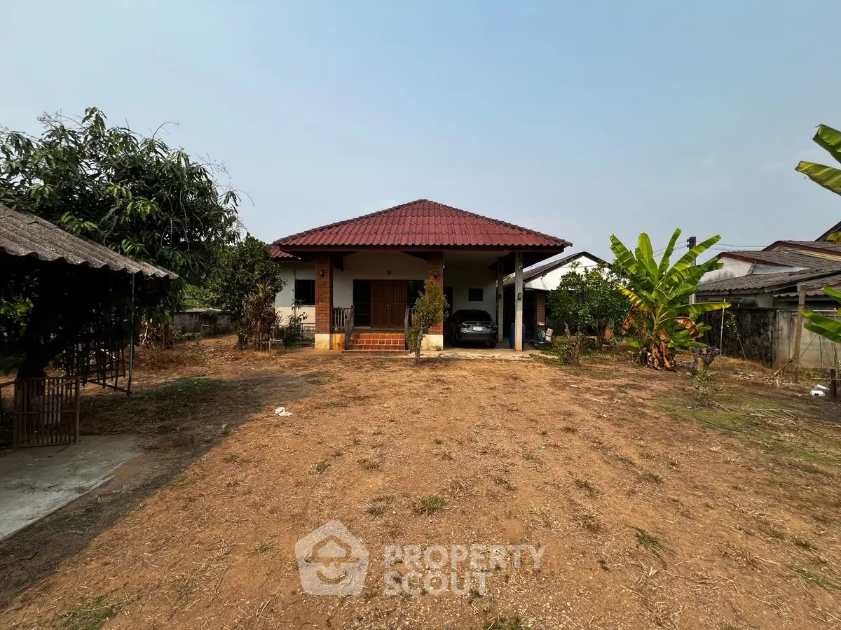 Charming rural house with spacious front yard and lush greenery, perfect for tranquil living.