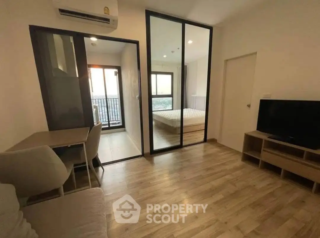 Modern apartment interior with wooden flooring, cozy living area, and bedroom with balcony view.