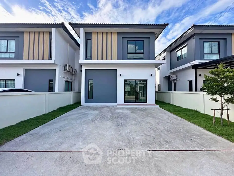 Modern two-story house with sleek design and spacious driveway in a suburban neighborhood.