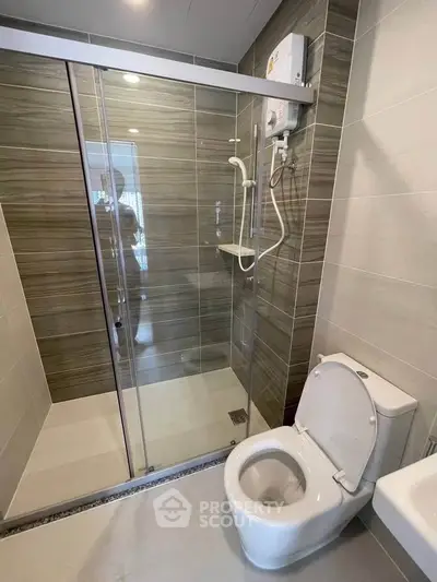 Modern bathroom with glass shower enclosure and sleek toilet design.