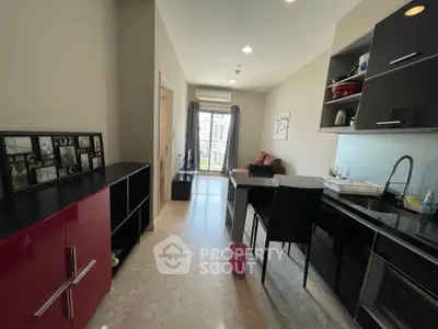 Modern apartment interior with sleek kitchen and cozy living area, featuring stylish cabinetry and natural light.