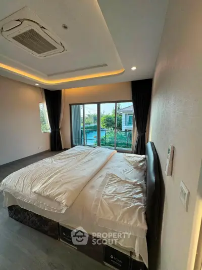 Spacious bedroom with large windows and garden view in modern home