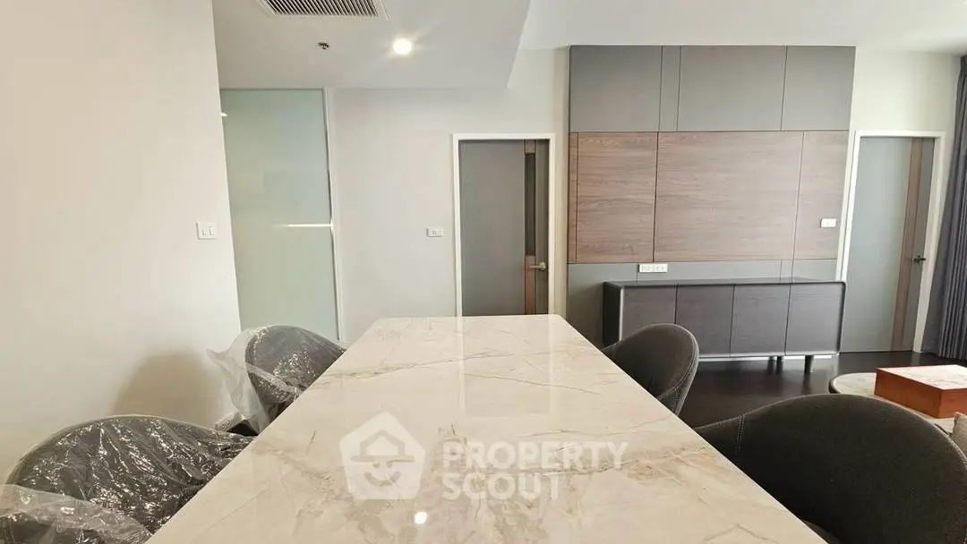 Modern dining area with marble table and stylish chairs in a contemporary apartment.