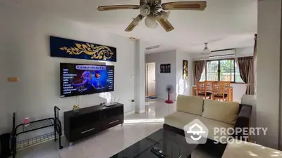 Spacious living room with modern decor and dining area, featuring a ceiling fan and large window for natural light.