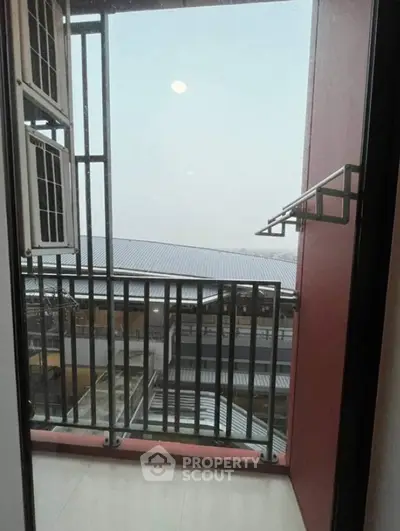 Modern balcony with sleek railing and expansive view of urban landscape.