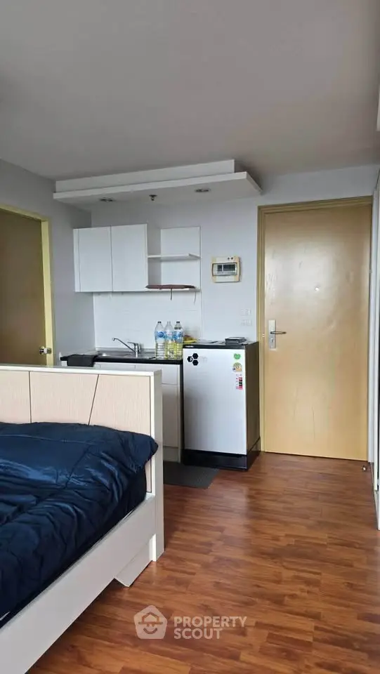 Compact studio apartment with kitchenette and cozy sleeping area, ideal for urban living.