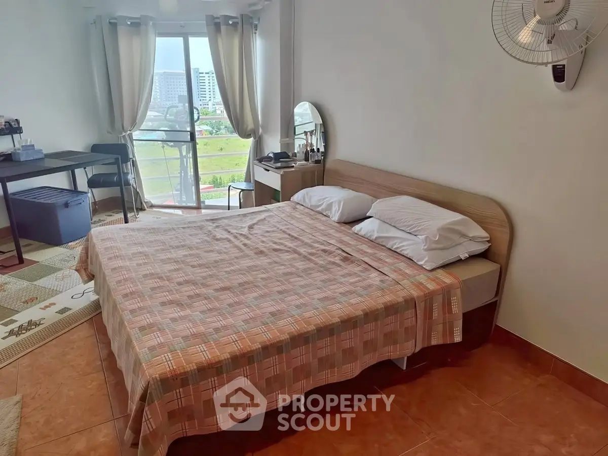 Spacious bedroom with balcony view in modern apartment