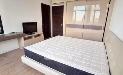 Modern bedroom with sleek furniture and large wardrobe in a stylish apartment.