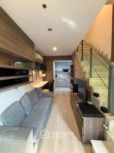 Modern living room with stylish decor and open layout leading to a sleek kitchen area.