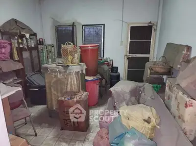 Cluttered storage room with various household items and boxes