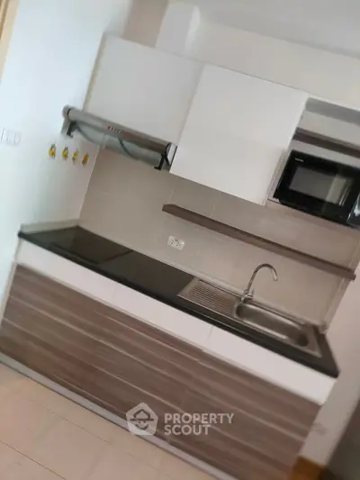 Modern kitchen with sleek cabinetry and built-in appliances in a contemporary apartment.