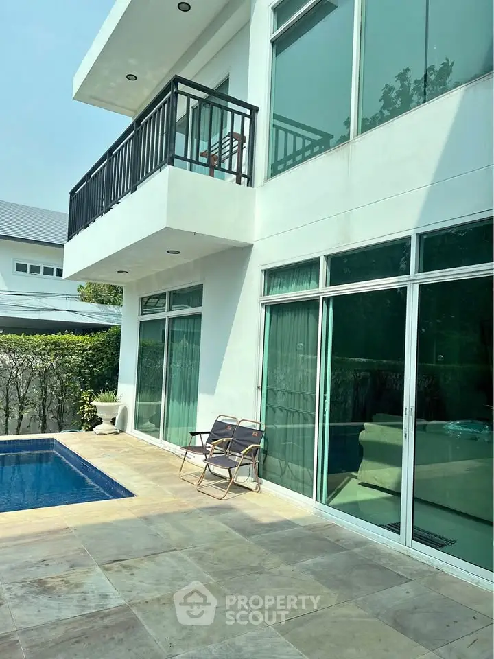 Modern home exterior with pool and balcony, perfect for luxury living.