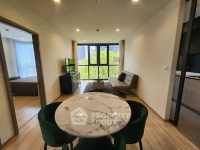 Modern apartment with open living and dining area, featuring a marble table and large windows with a view.