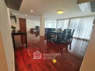 Spacious living room with polished wooden floors and elegant dining area