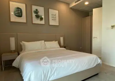 Modern bedroom with elegant decor and cozy ambiance, featuring stylish artwork and comfortable bedding.