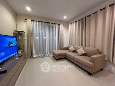 Modern living room with sleek furniture and large windows for natural light.