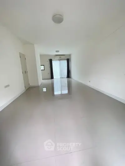 Spacious empty room with glossy tiled floor and large window