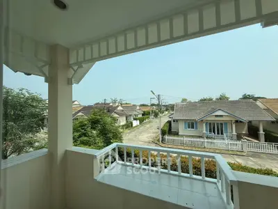 Charming balcony view overlooking a peaceful suburban neighborhood with lush greenery and cozy homes.