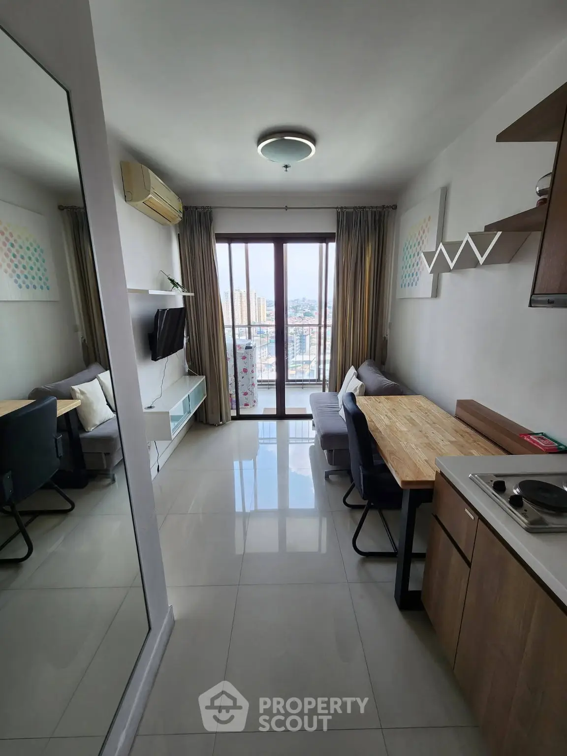 Modern living room with city view, featuring sleek furniture and open layout.