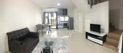 Modern living room with sleek furniture and open kitchen layout in a stylish apartment.