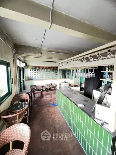 Charming interior with green-tiled bar and cozy seating area, perfect for entertaining guests.
