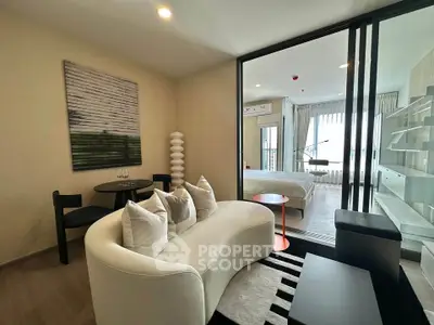 Modern living room with stylish furniture and open view into a cozy bedroom