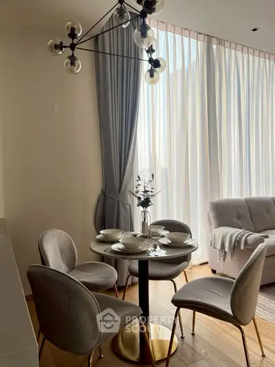 Elegant dining area with modern chandelier and cozy seating in a bright living room.