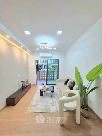 Modern living room with stylish decor and large sliding doors to balcony.