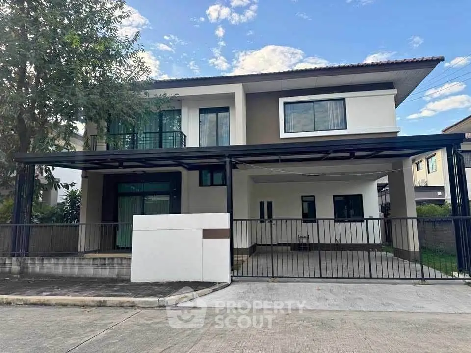 Modern two-story house with spacious driveway and balcony in a suburban neighborhood.
